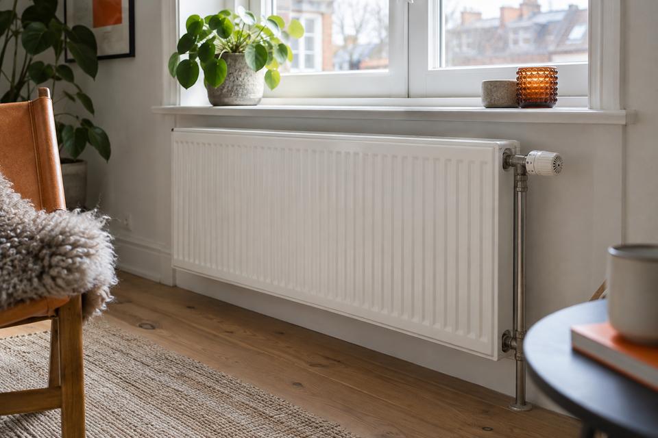 Radiator og termostat under et vindue
